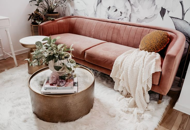 pink couch with brass coffee table and white fluffy rug