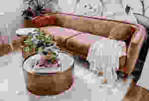 pink couch with brass coffee table and white fluffy rug