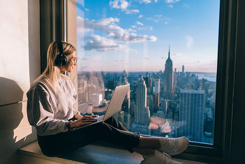 Millennial female freelancer in electronic headphones for noise cancellation listening pos