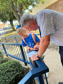 Superintendent Surratt reviews  student work