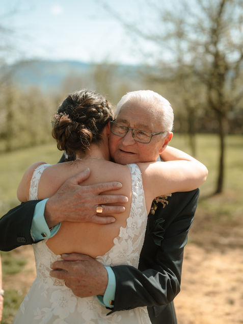Papa umarmt Braut nach der Trauung und gratuliert ihr.