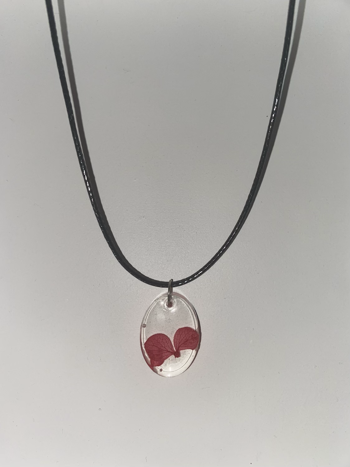 Clear oval resin pendant with flower