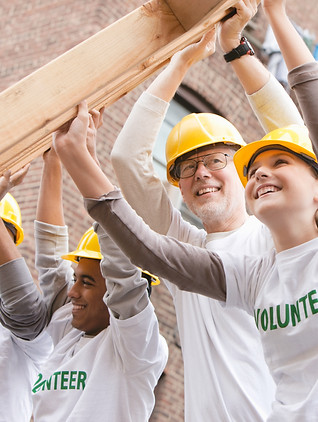 Volunteers Lifting Construction Frame