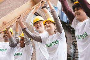 Volunteers Lifting Construction Frame