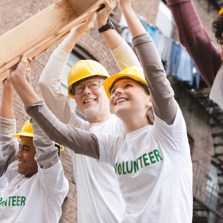 Volunteers Lifting Construction Frame