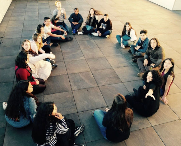 Grupo de jóvenes sentados en círculo en un taller.
