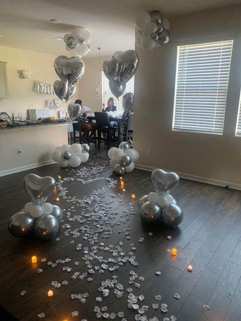 chrome silver helium balloons and white rose petals for wedding proposal