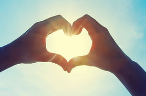 Female hands in the form of heart agains