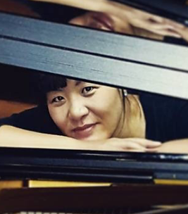 Jungle Kim peeks out from beneath a grand piano lid.