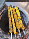 A pot filled with skewers cooking on a grill, creating a delicious barbecue meal.