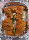 A crumpled sheet of shiny aluminium foil on a table with prepared meat