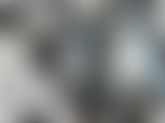 A group of repeatable metal parts sitting in neat stacks and rows on a manufacturing workplace surface.