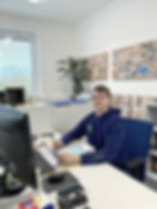 A photo of an employee sitting at a computer in our aftercare department