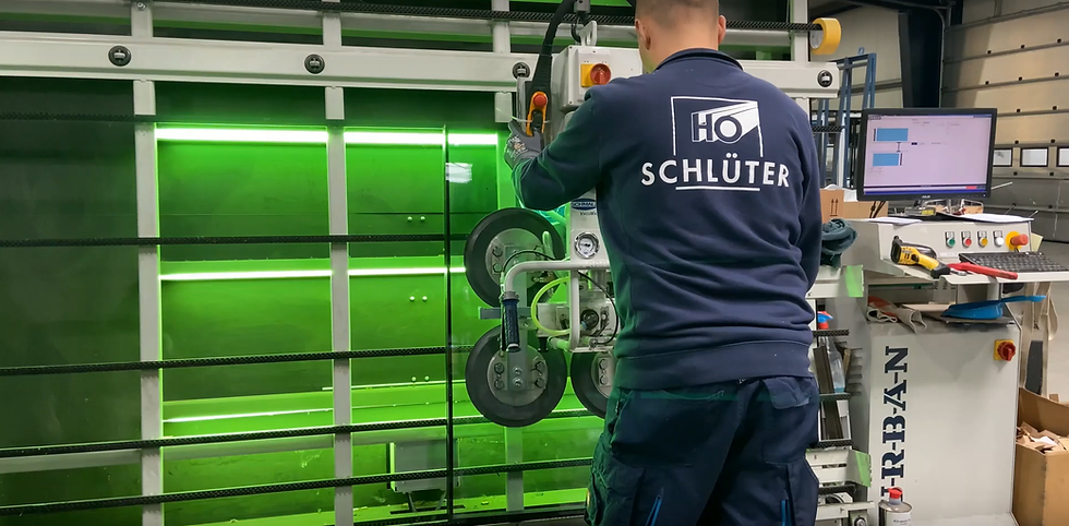 A photo of schlüters manufacturing facility showing an employee checking the glass for imperfections.