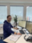 A photo of an employee standing at a computer in our planning department.