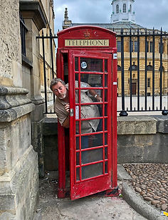 Michael Scott Lees Photographer leaning out of a red telephone box in Oxford England with a comical look on his face