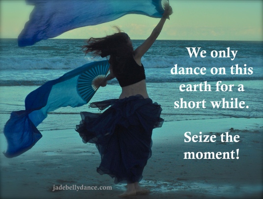 Silhouette of a dancer with blue fabric on a beach at sunset. Text: "We only dance on this earth for a short while. Seize the moment!"