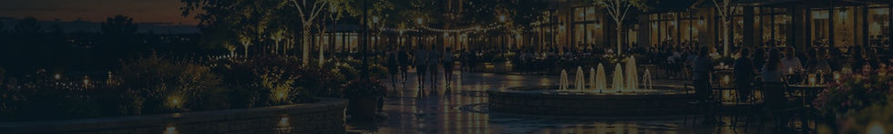 The Schaumburg town plaza at dusk with a fountain and string lights