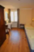 Cozy room with window, wooden floor and simple furnishings at Hotel Blauer Bock