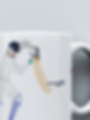 Close up of a ceramic mug with a design of a person playing cricket on it