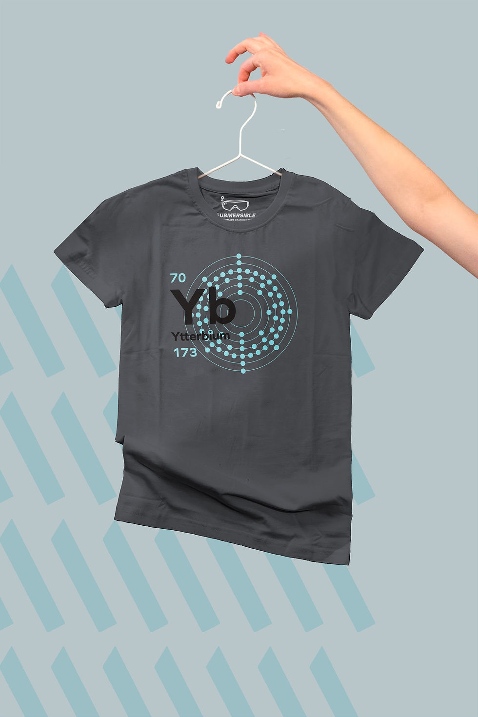 Person holding a t-shirt on a hanger showing the design of the element Ytterbium