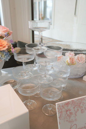 Ribbed coupe champagne glass tower displayed as the centerpiece of the mimosa bar.