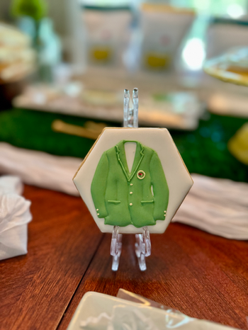Decorative display of custom Masters-themed cookies styled as part of a baby shower dessert and décor installation.