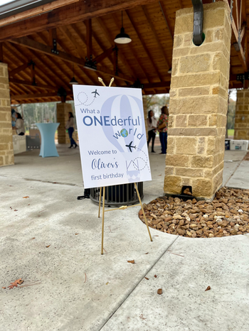 Custom welcome sign displayed on a gold easel for an A ONEderful World first birthday party.