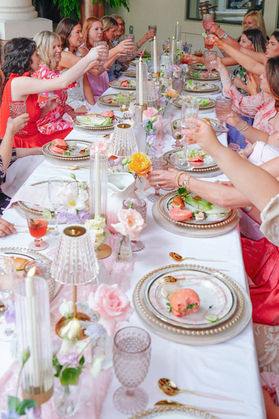 Luxury bridal picnic tables featuring oversized pillows, floral arrangements, and romantic table lighting.