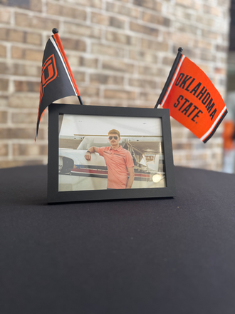 Personalized graduation cocktail table styling with custom framed photos and Oklahoma State accents.