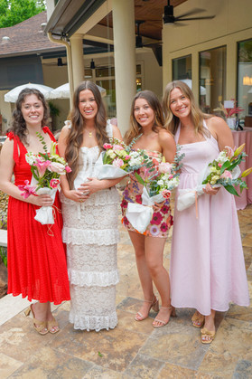 Guests posing with handmade bouquets created at the interactive flower bar.