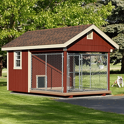 Red dog kennel with attached chain-link outdoor run on green lawn.