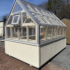 A wooden-base greenhouse with clear roof panels, outdoors under blue sky.