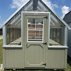 Small light green wooden greenhouse with glass roof and windows