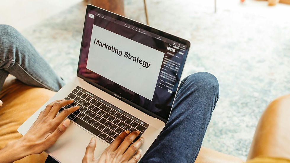 Close-up of hands using a laptop displaying a marketing strategy presentation indoors.
