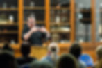 David Rees guesturing as he gives a talk about his work on the cover of Sequences & Pathogens.