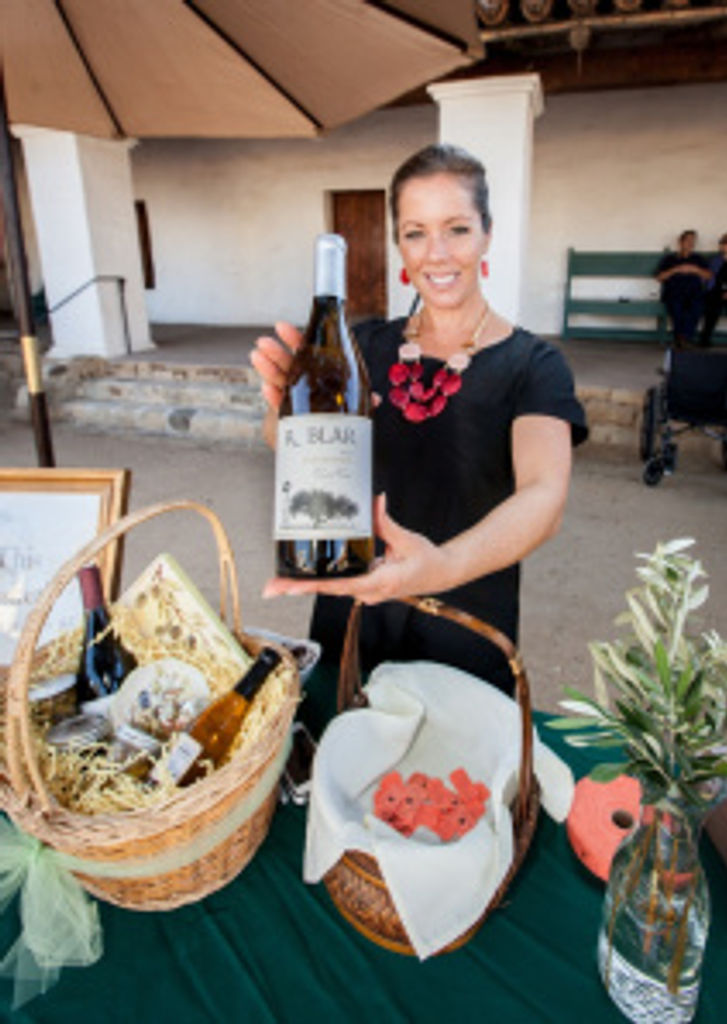 Roblar Winery Sales Manager Chemayne Faulconer showing off Roblar’s Chardonnay at the raffle table. Photo by Fritz Olenberger.