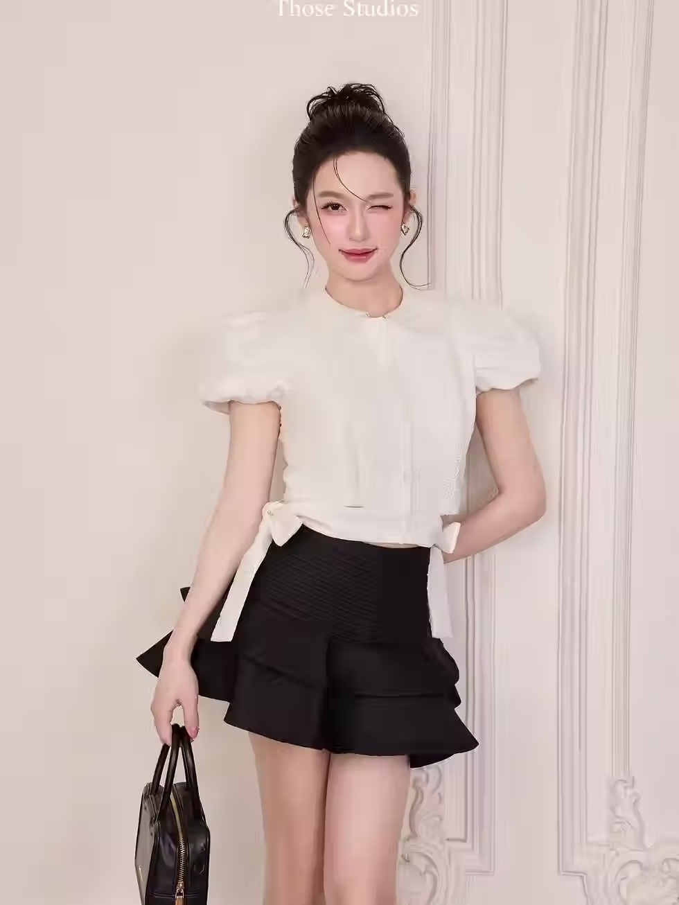 Those Studios’ CAILY SET featuring a white round-collar blouse and tiered black mini skirt, perfect for any outing.
