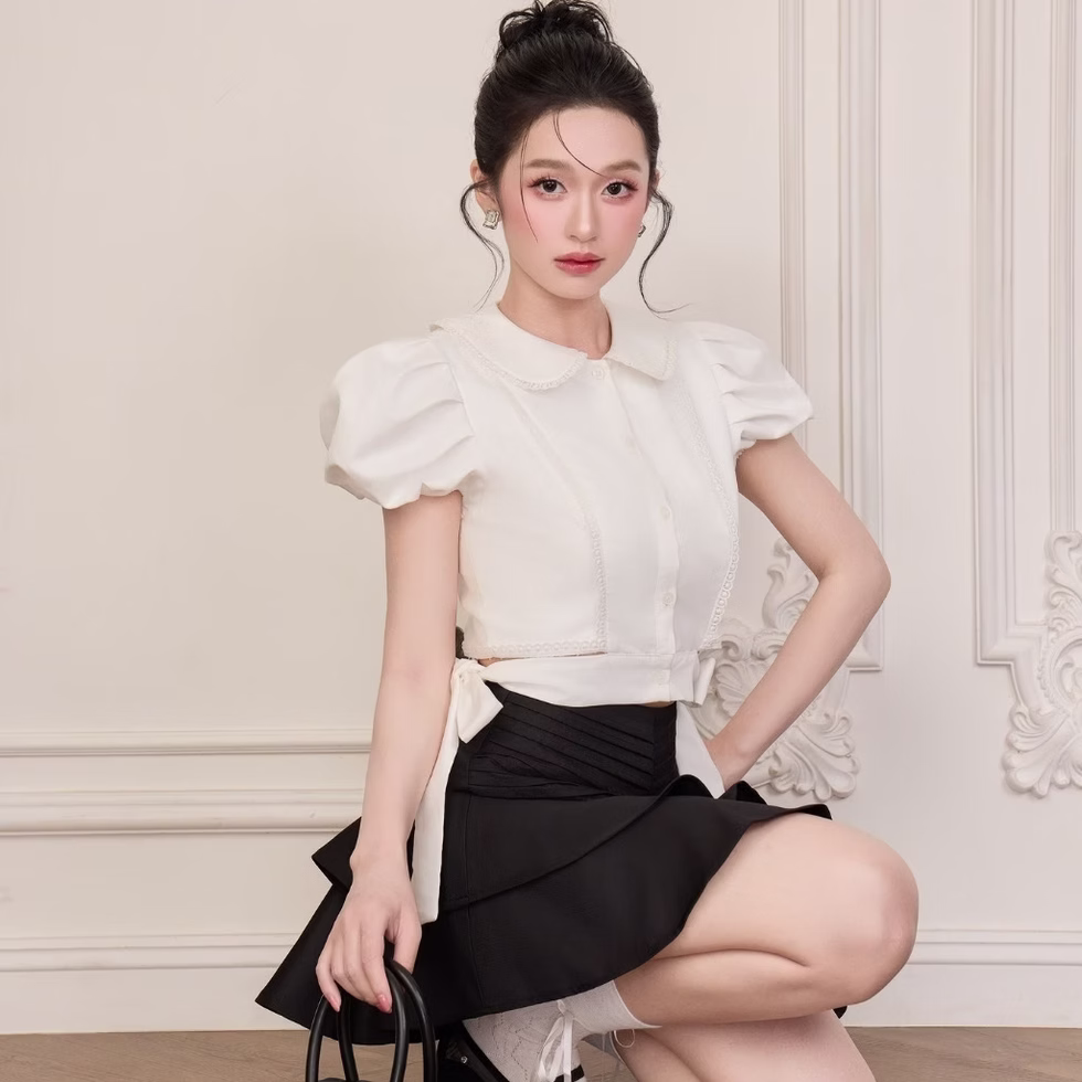 Those Studios’ CAILY SET featuring a white round-collar blouse and tiered black mini skirt, perfect for any outing.