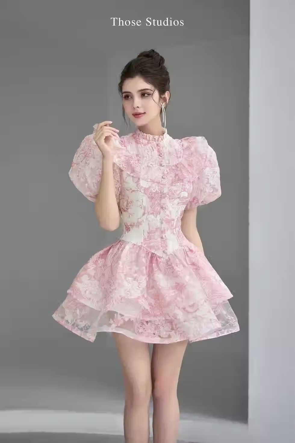 Model in Those Studios Regina Dress, pink floral puff sleeve mini dress with layered ruffle skirt, vintage style.