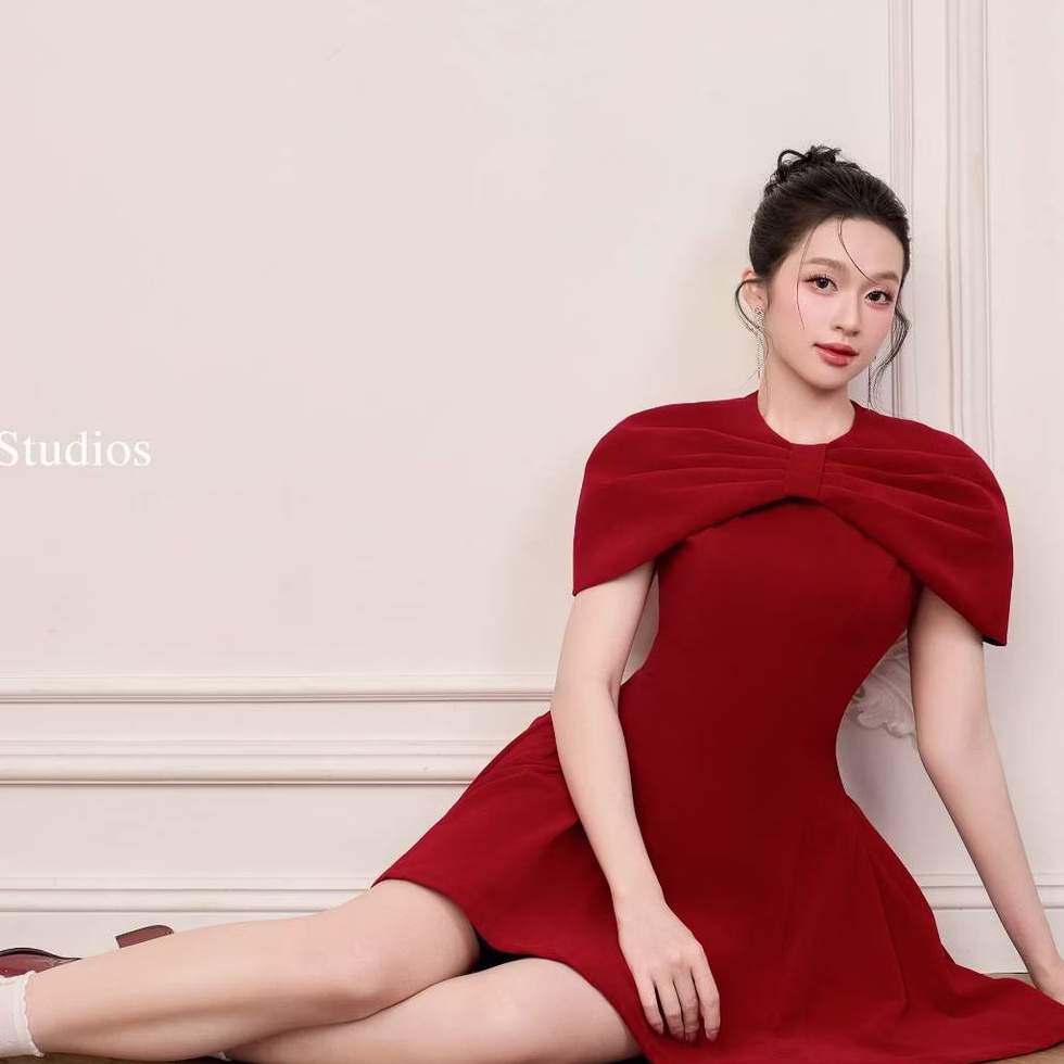 Red Roselle dress with bow cape neckline and fit-and-flare shape, elegant and feminine design.