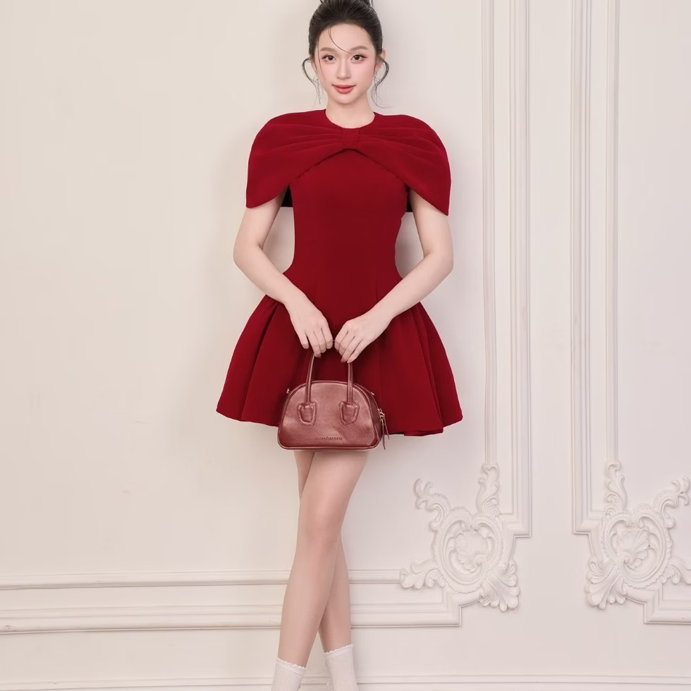 Red Roselle dress with bow cape neckline and fit-and-flare shape, elegant and feminine design.