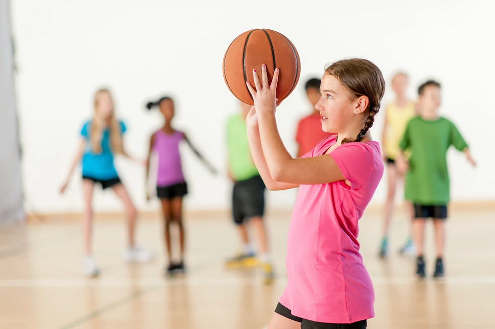 Girl in pink shirt holding basketball in gym class