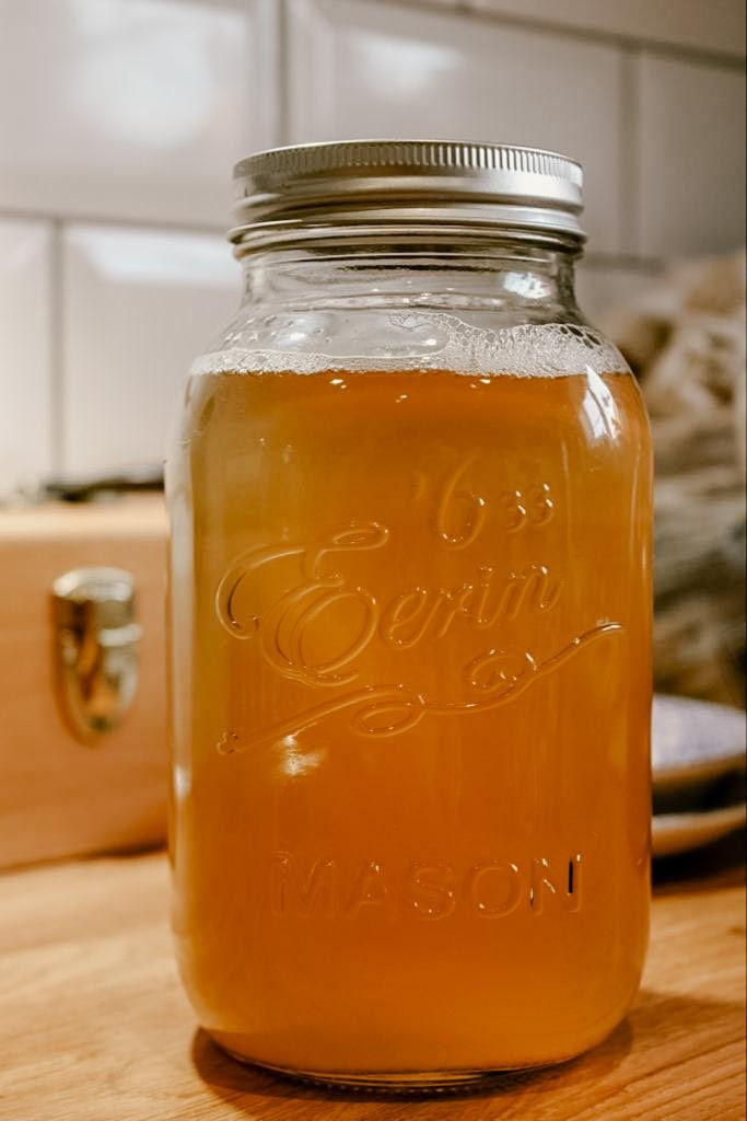A jar of liquid soap nut laundry detergent on a counter.