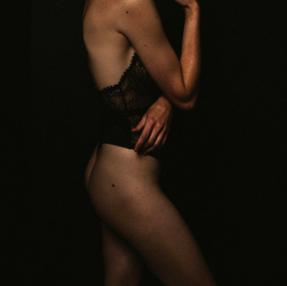 Quarter body pose of woman in black lingire during boudoir photoshoot in Athens Pennsylvania studio.