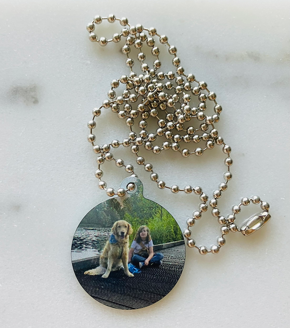 Thumbnail: Twee metalen fotohangers aan ballchain ketting, bedrukt met foto’s van een assistentiehond en een kind met hulphond, geschikt