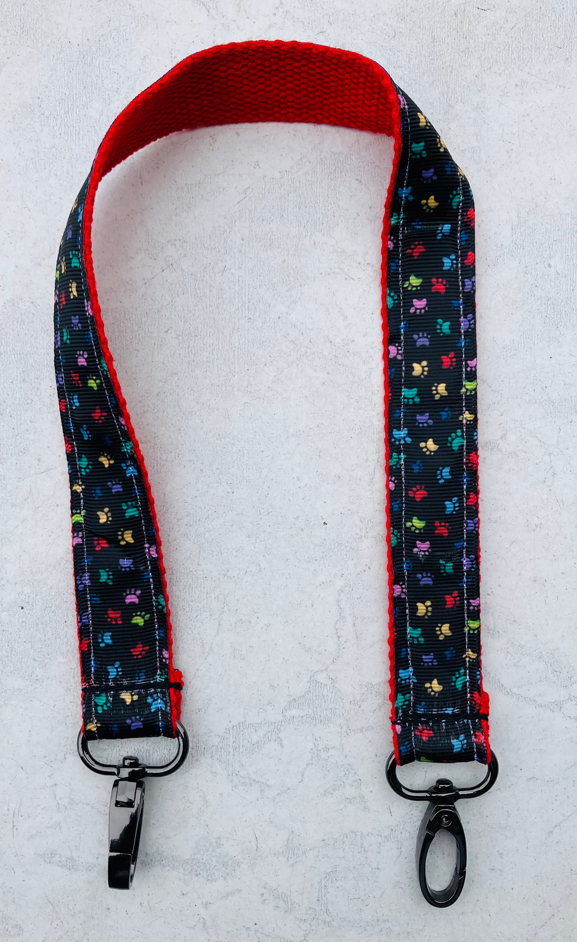 pullstrap rood/zwart met regenboog gekleurd pootjespatroon