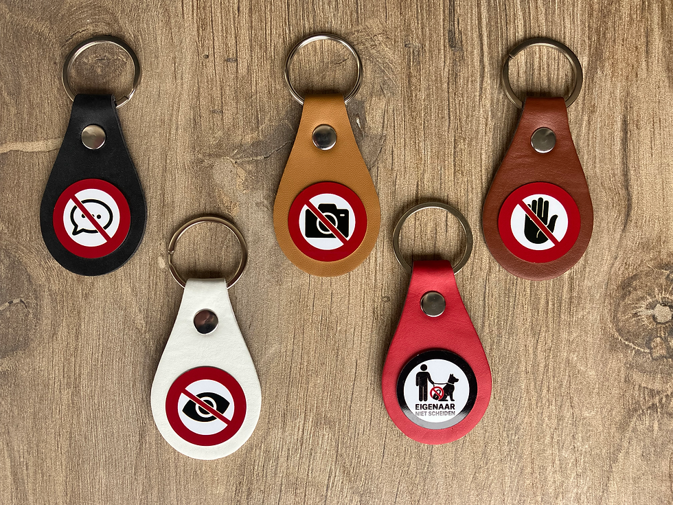 Diverse sleutelhangers met waarschuwingssymbolen op houten achtergrond.