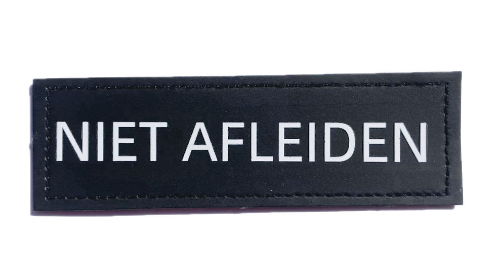Thumbnail: "Zwarte hulphond patch met witte tekst ‘Niet Afleiden’, klittenband bevestiging 16x5 cm."