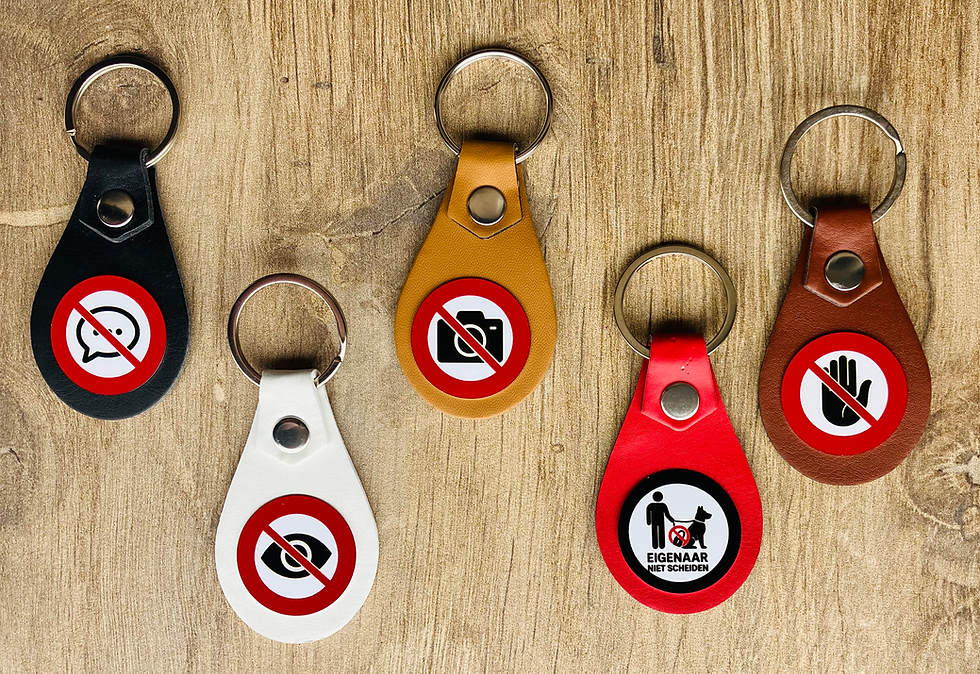 “Sleutelhangers met rode en witte waarschuwingstekens op hout.”